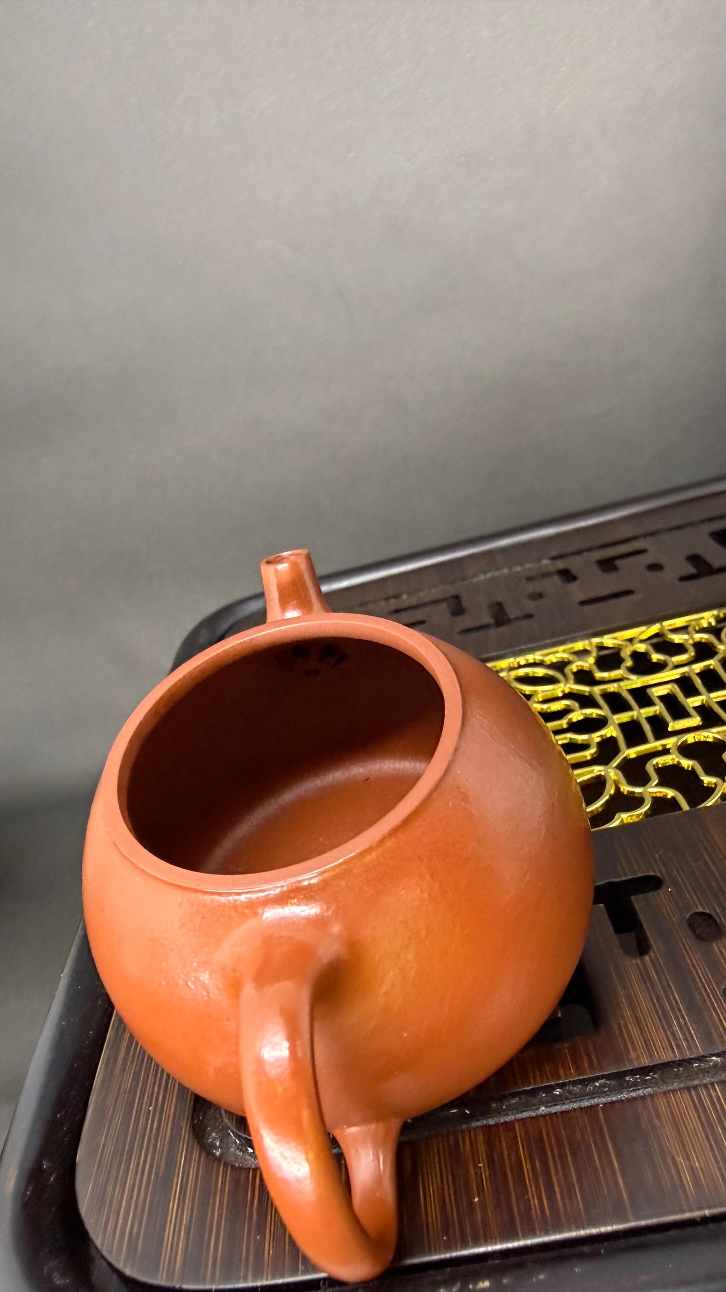 “Sunlit Ember Yixing teapot on tea tray”