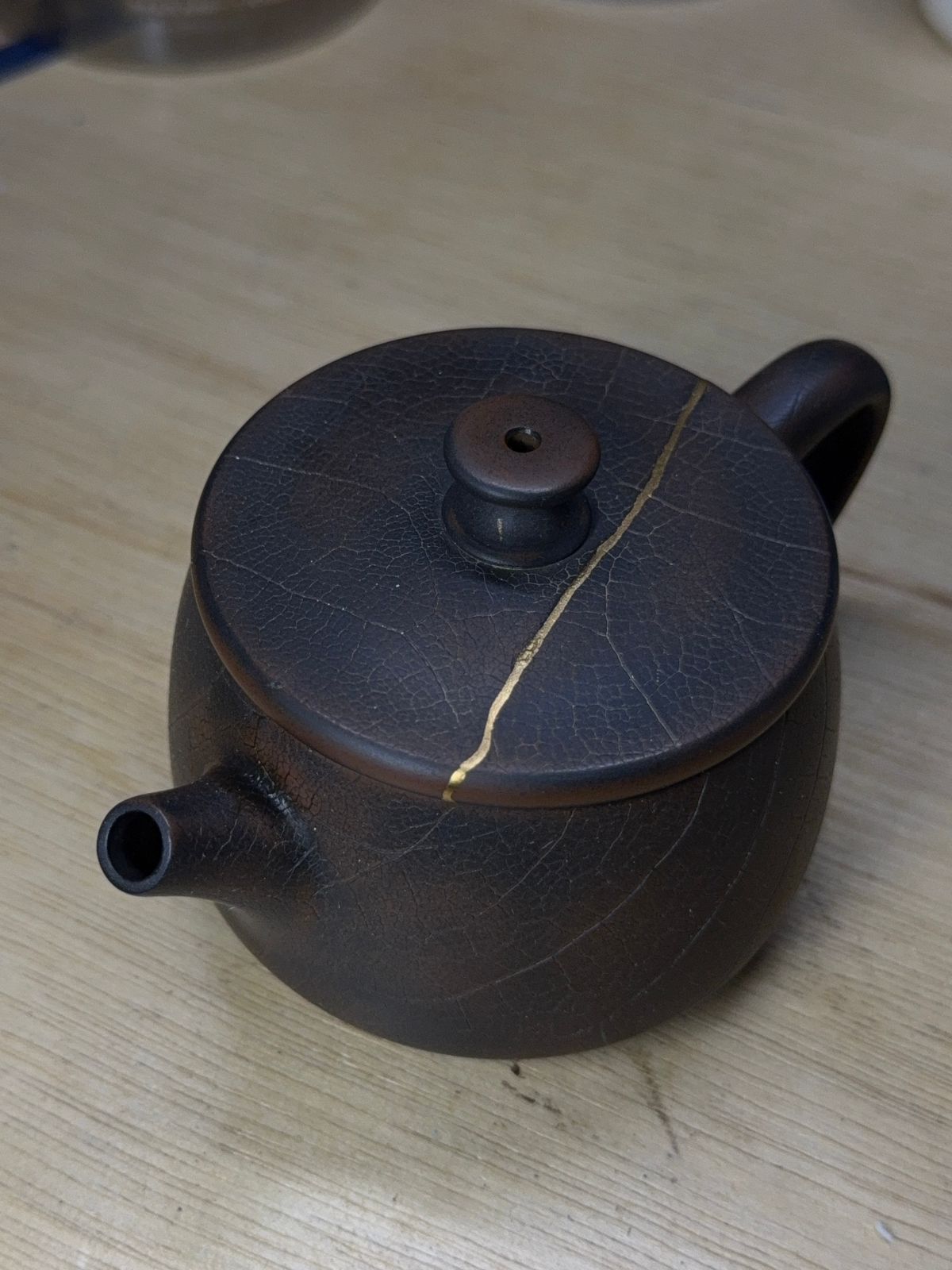 “Dark clay teapot with fossil leaf texture”