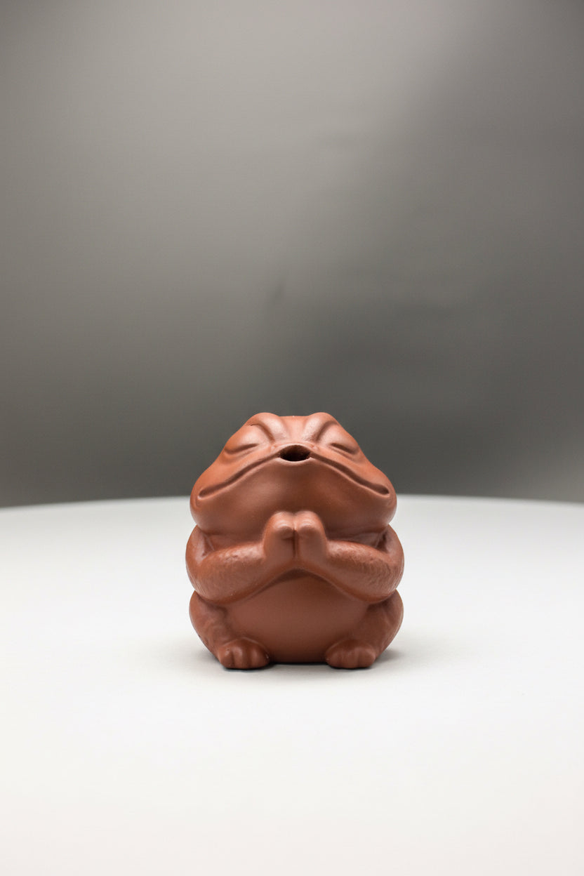 “Meditating frog tea figurine on tea tray”