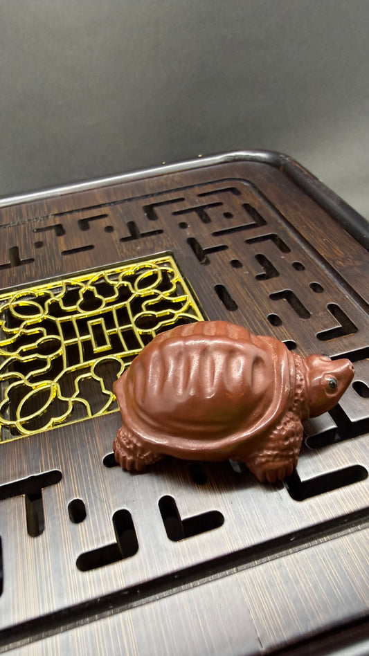 “Orange clay turtle tea figurine”
