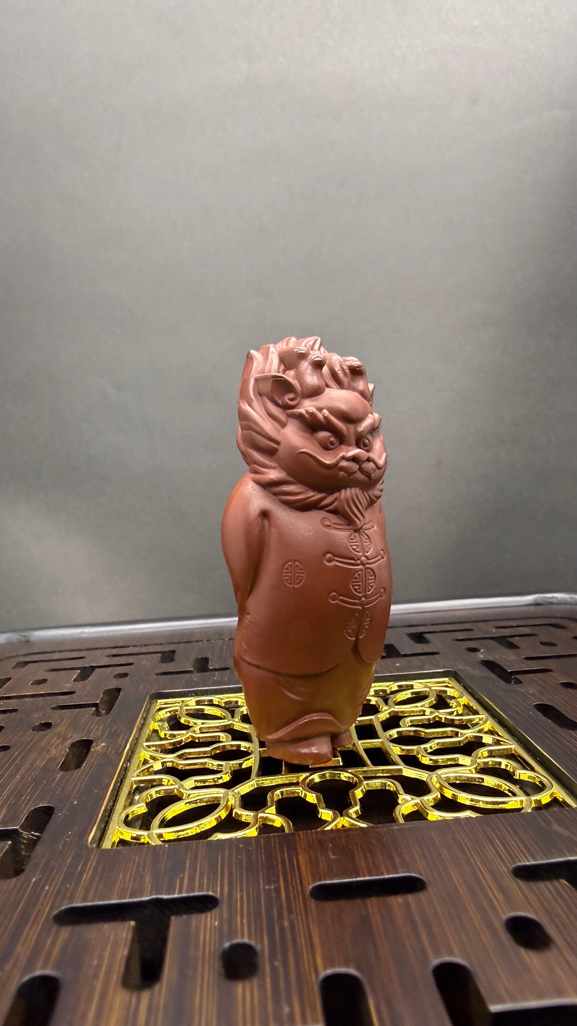 “Yixing clay lion tea figurine in traditional Chinese clothing”