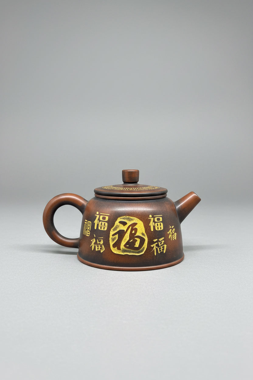 “Brown-orange Yixing clay teapot with engraved characters”