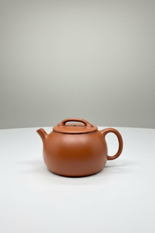 “Orange Yixing clay teapot with rounded form”