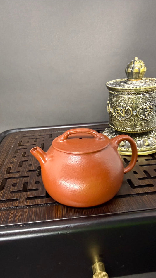 “Orange Yixing clay teapot with rounded form”