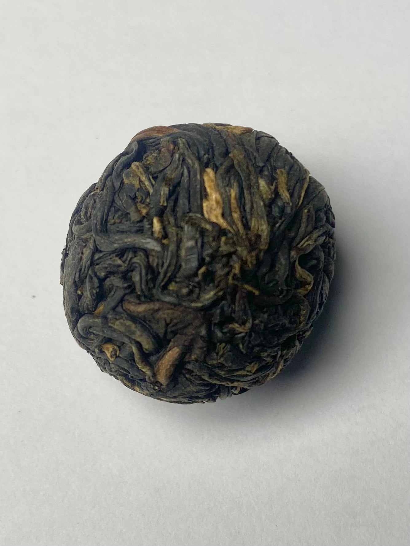 Pearl of Earth Dragon aged white tea ball unfurling in glass cup – Yunnan private garden Indonesia