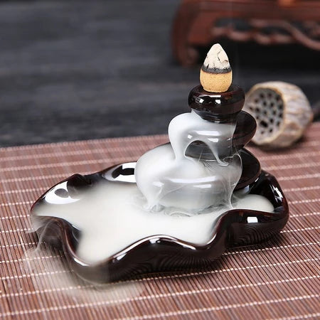 Black ceramic tiered backflow incense burner with cascading waterfall smoke effect